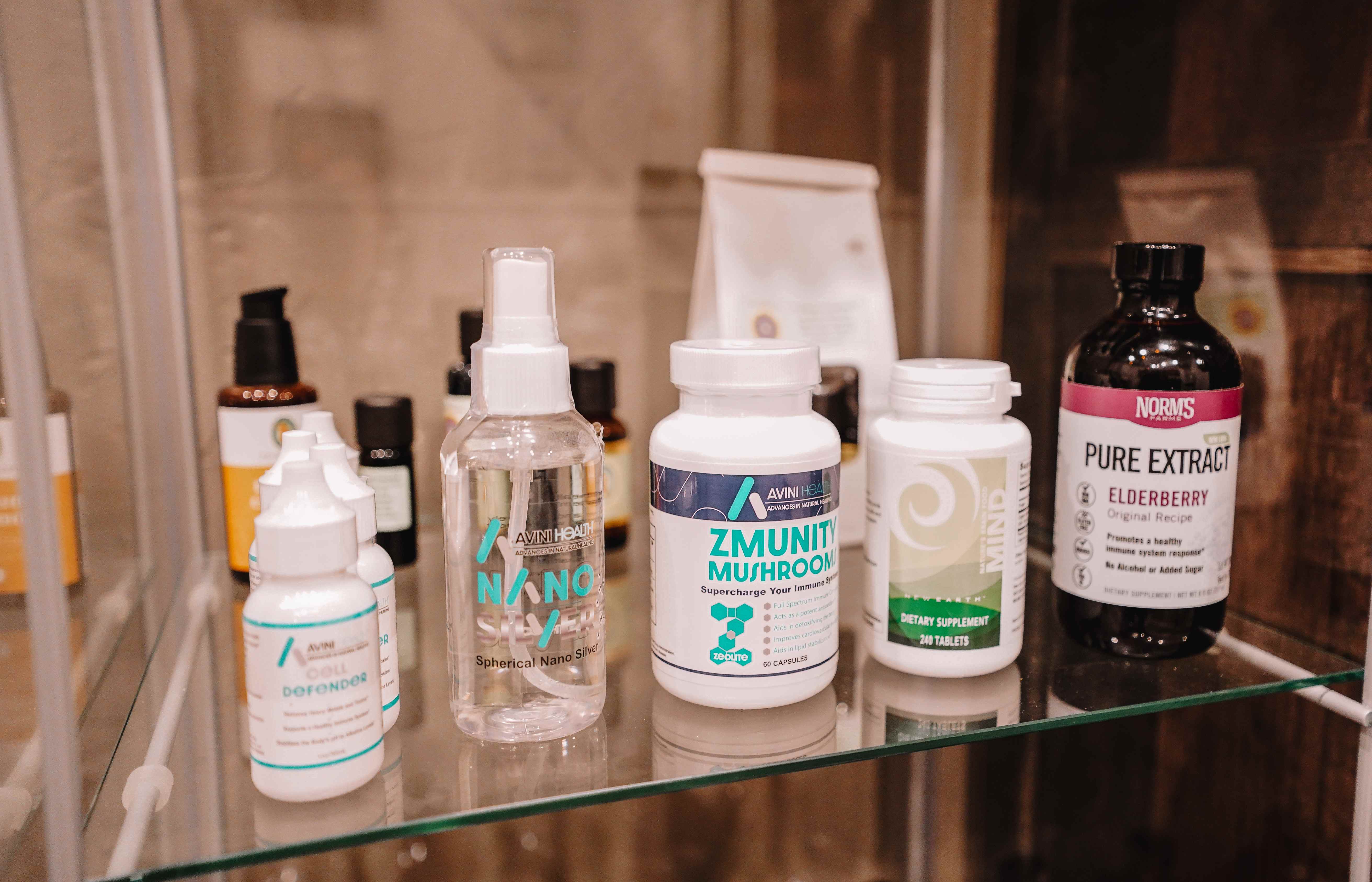 Avini Health, New Earth and wellness supplements on a glass shelf