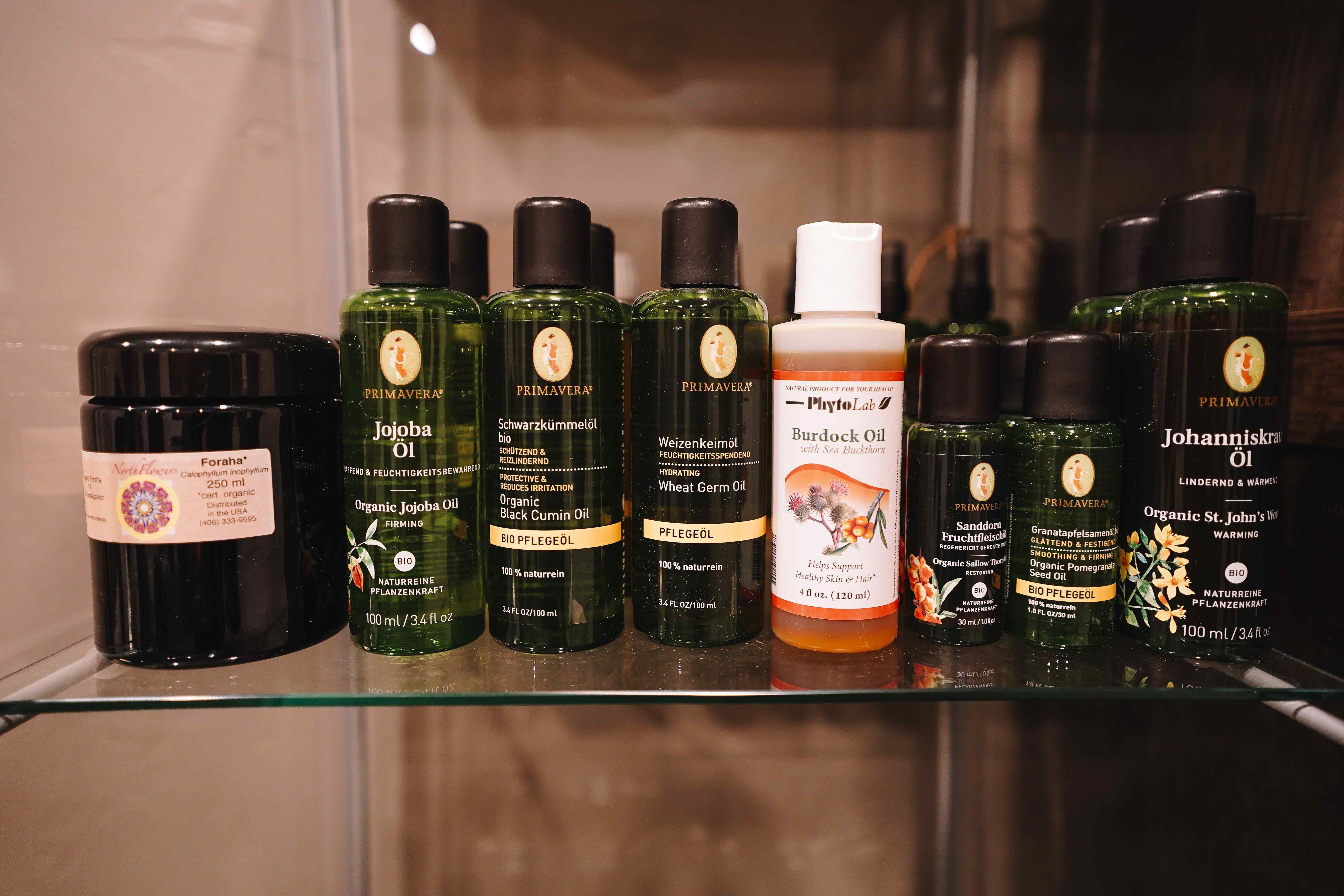 Primavera organic carrier and body oils on a glass shelf
